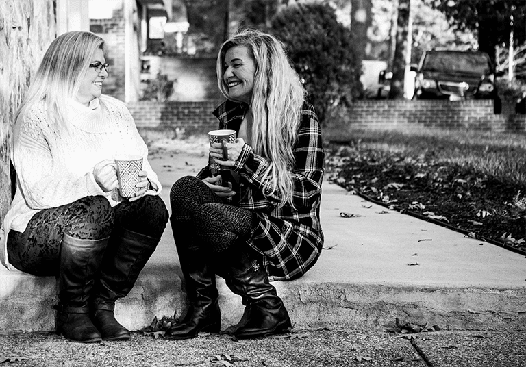 Amy, patient with Pseudobulbar Affect (PBA) and her friend and caregiver Laura, talking over coffee